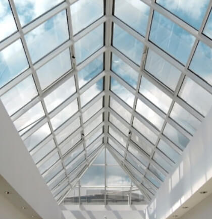 A triangular glass ceiling with coated metal pieces and glass
